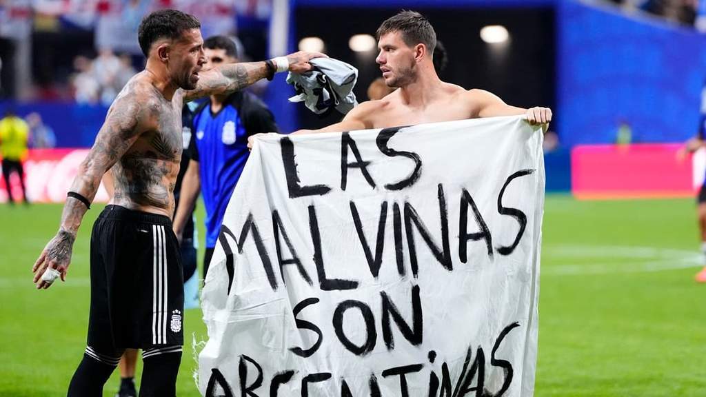 Pemain Argentina membentangkan spanduk klaim Kepulauan Malvinas setelah mengalahkan Inggris