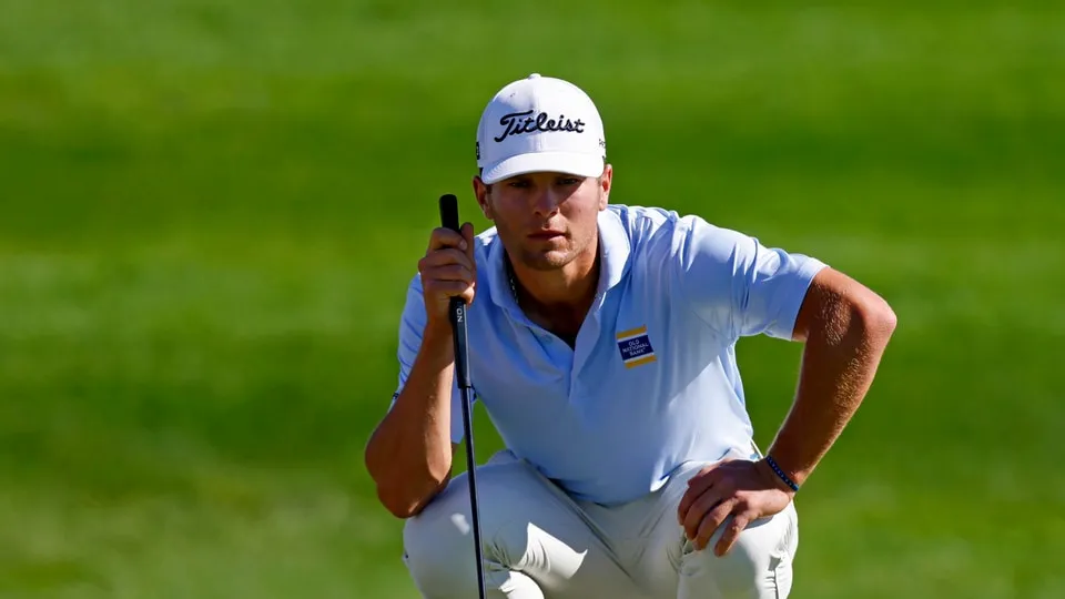 Michael Brennan mengangkat trofi kemenangan Wyndham Championship di Sedgefield Country Club.